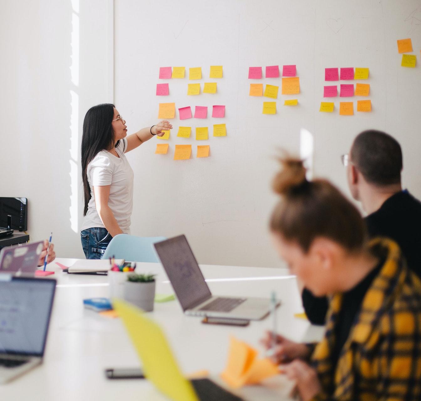 woman placing sticky notes on wall